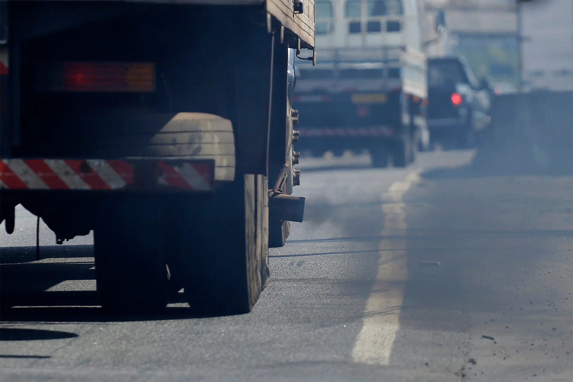 Closeup view of a truck's exhaust letting out CO2 emissions.