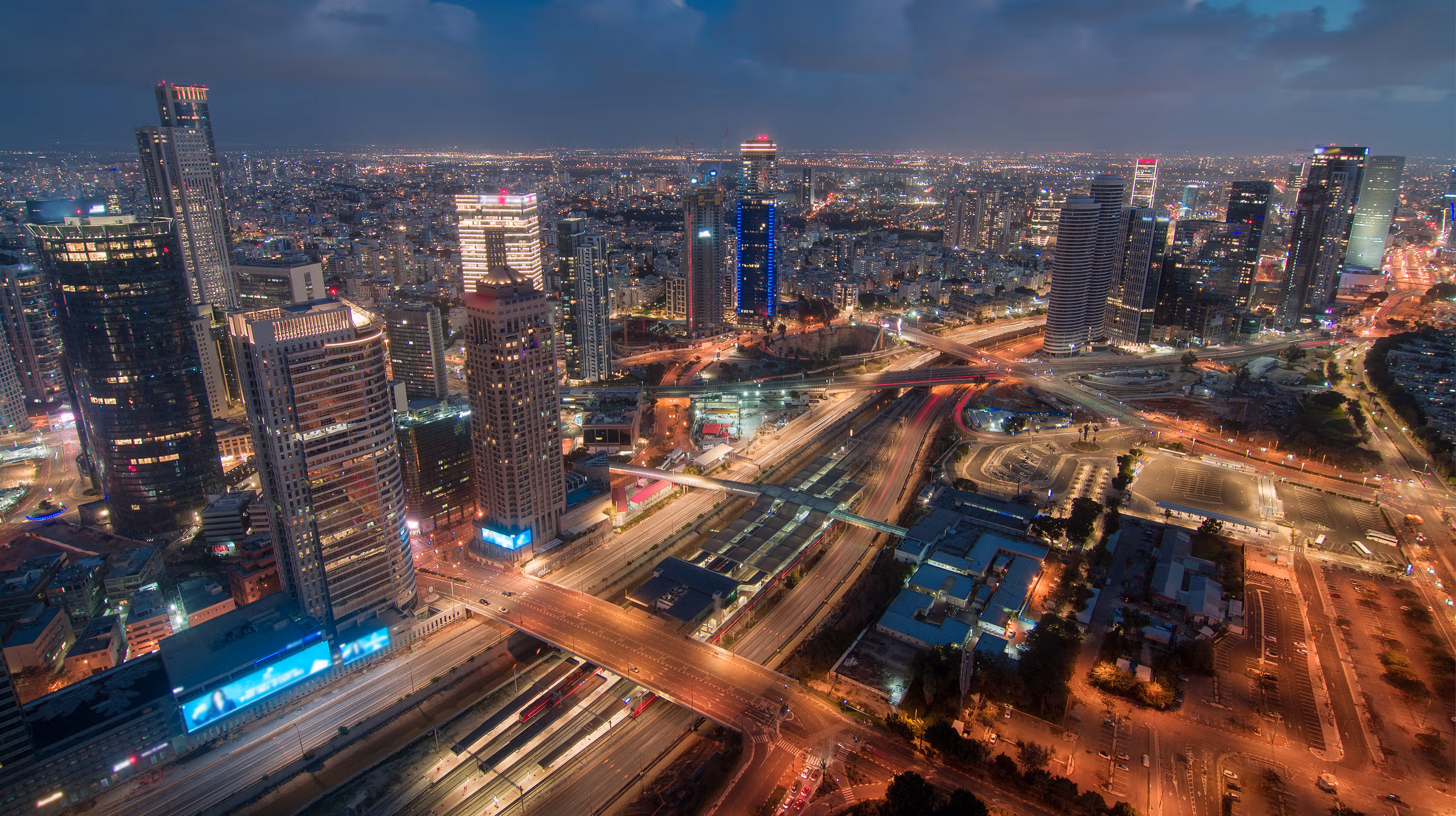 Night skyview of a city with cars driving buy on a freeway.