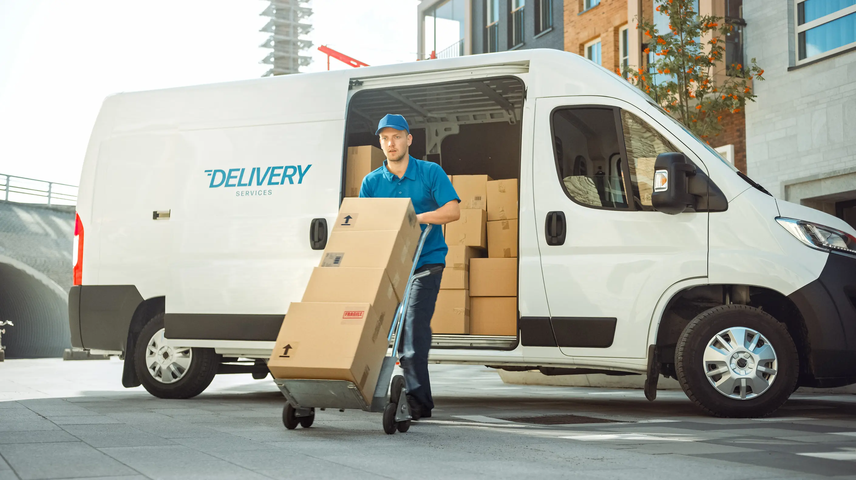 The delivery driver removing packages from his van in order to bring them to a destination
