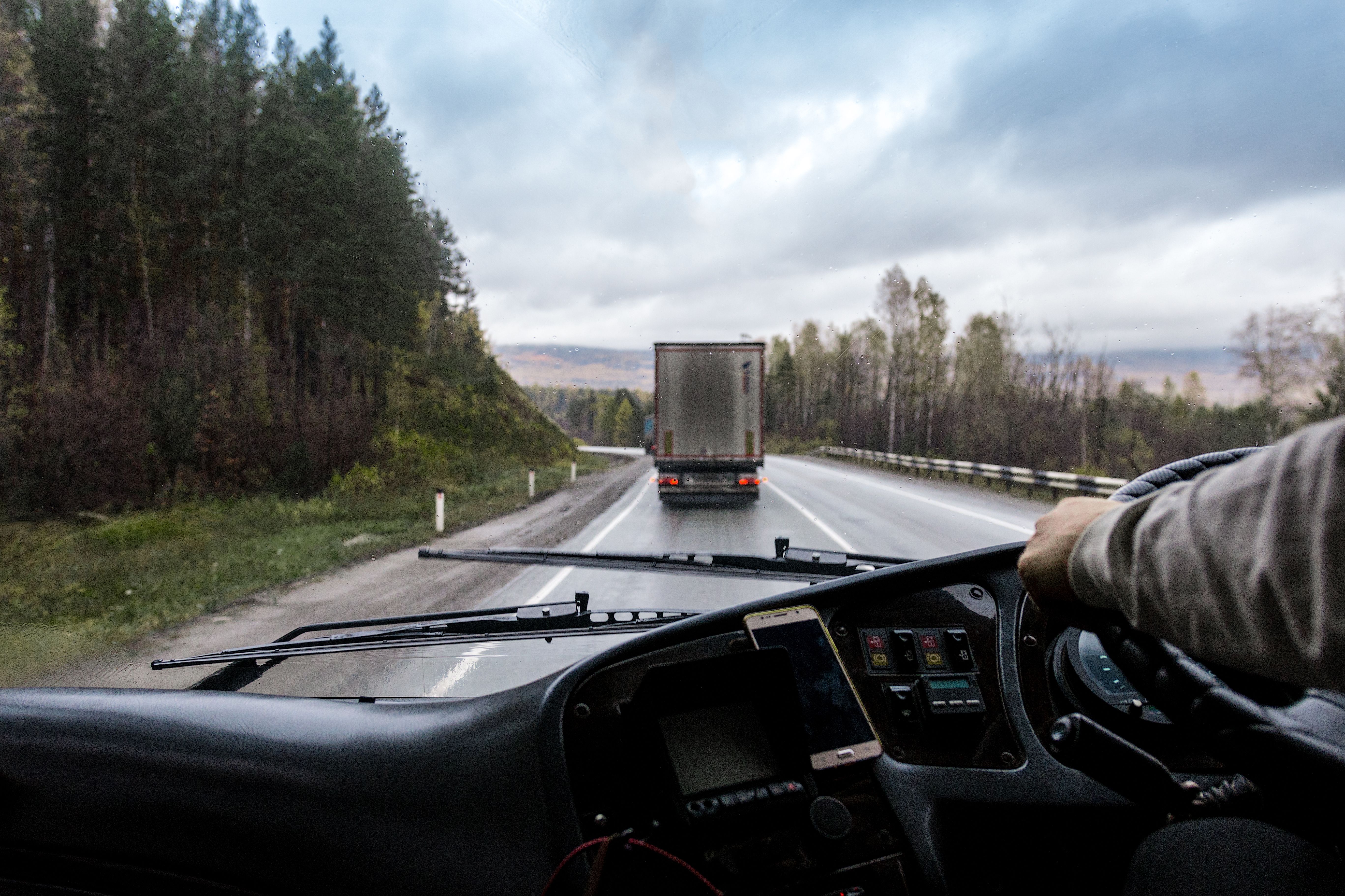 In cabin view of a truck driver driving down a road.