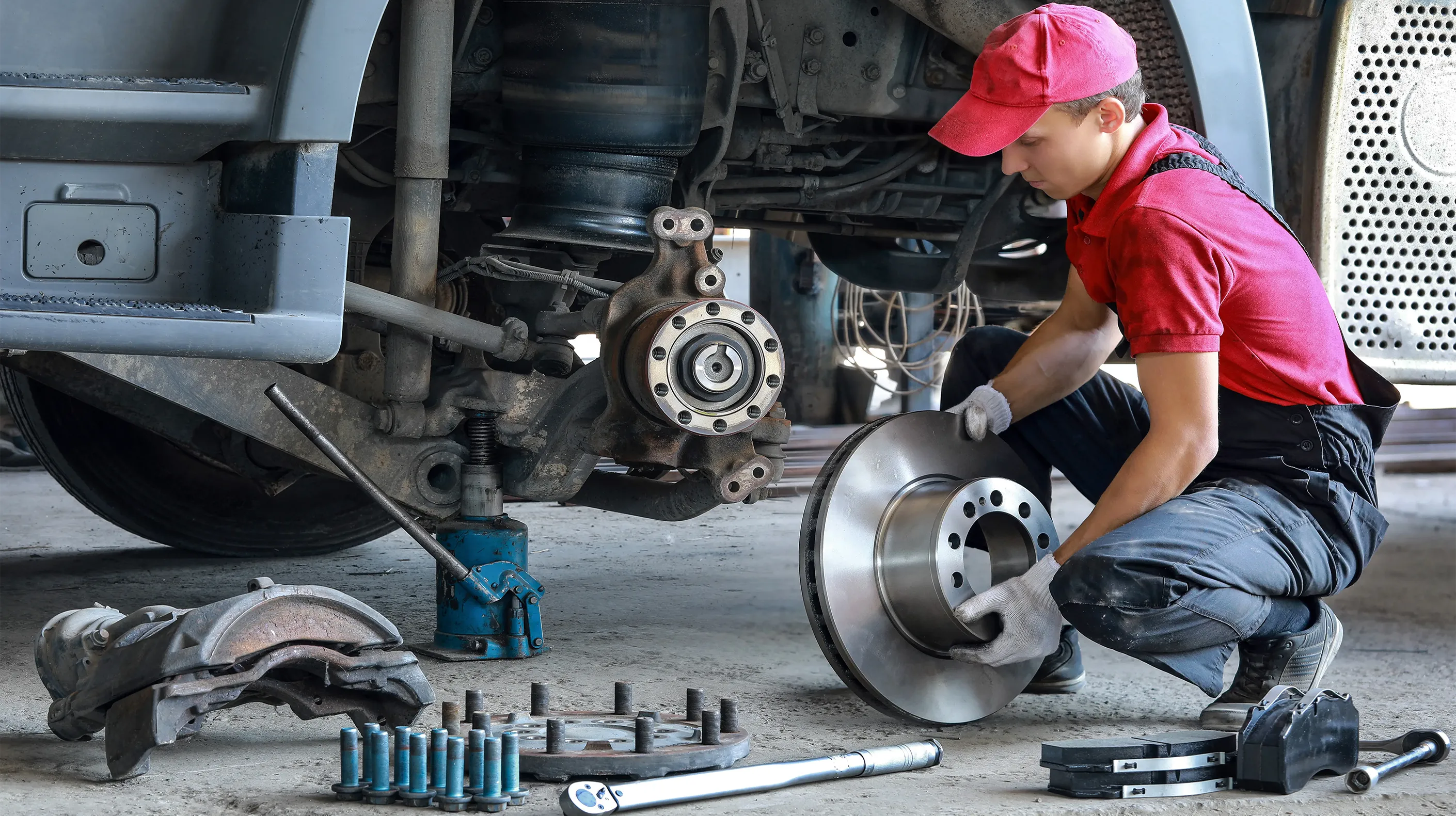 Photograph of a mechanic performing fleet maintenance on a vehicle's tyre.