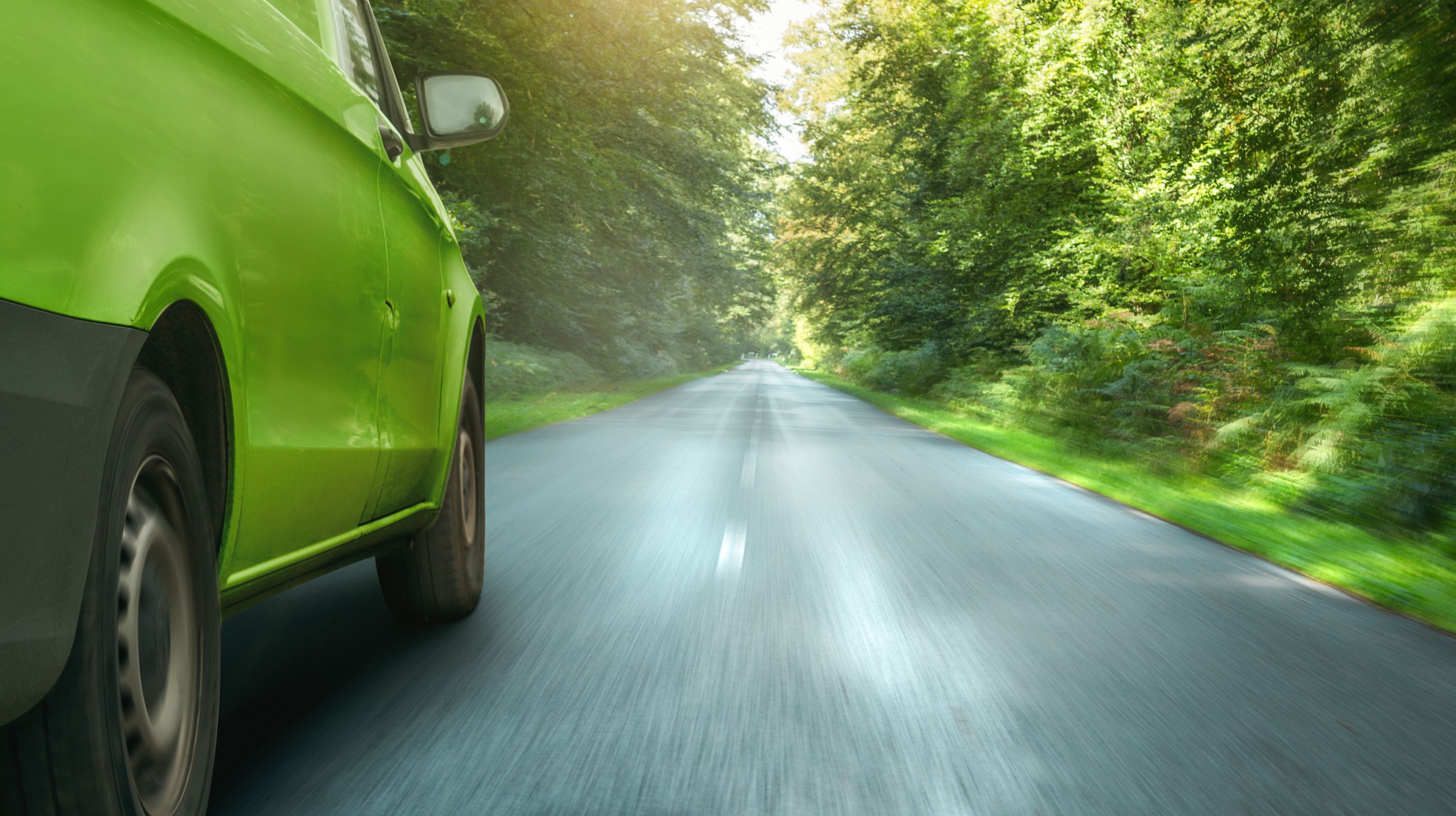 Langs groen rijdende auto boven blog over duurzaam wagenparkbeheer