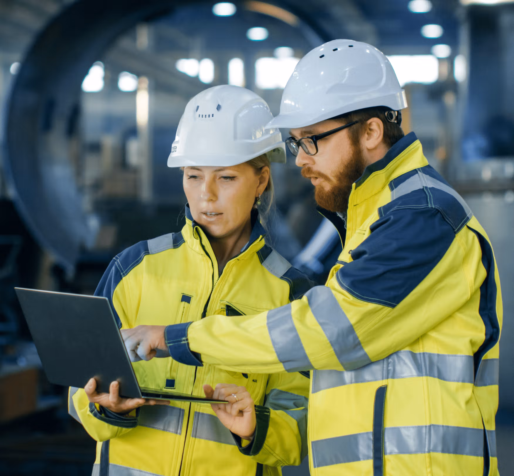 Workers looking at a laptop and discussing information on it.