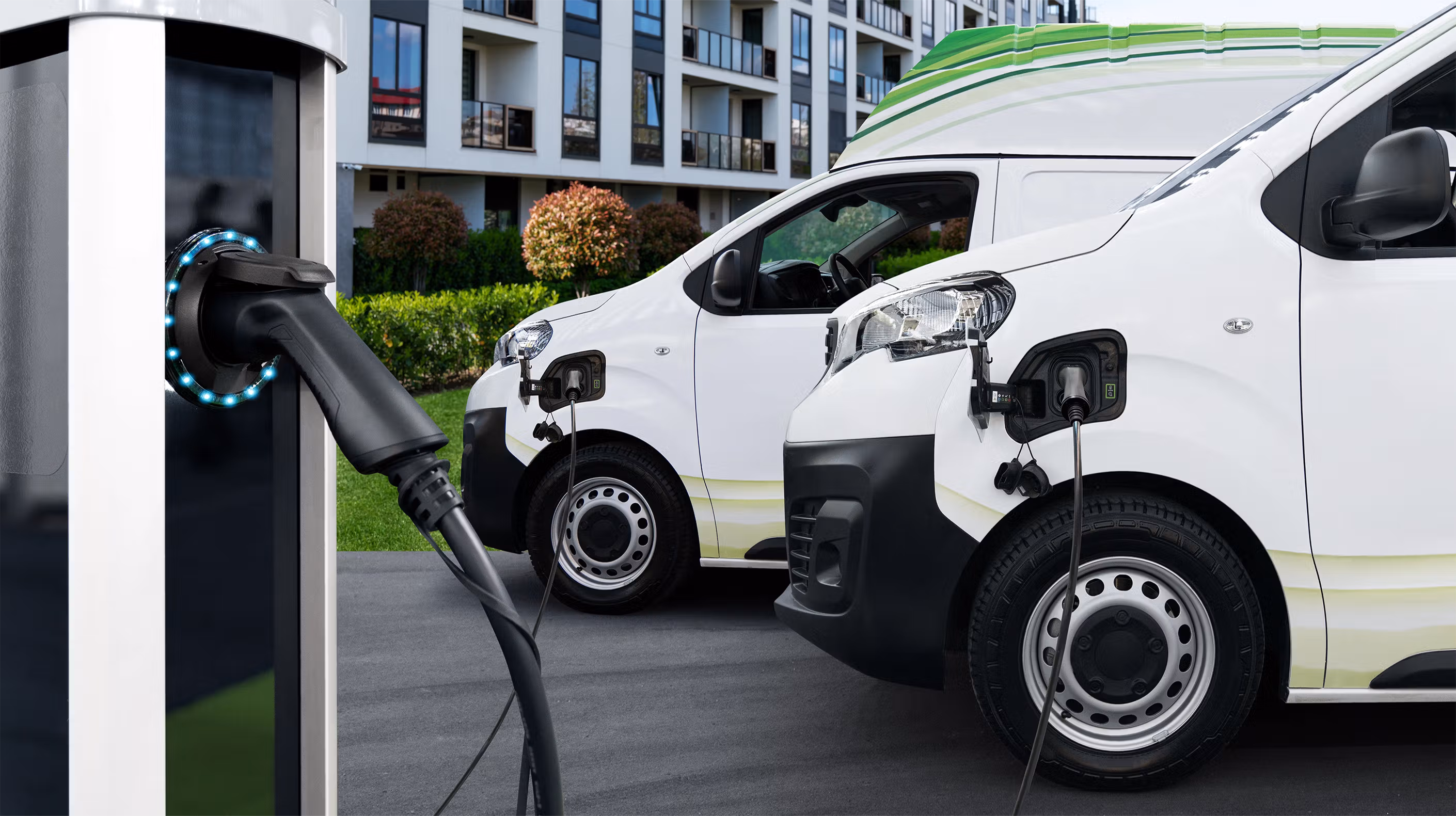 Side view of an electric fleet vehicle being charged at a station.