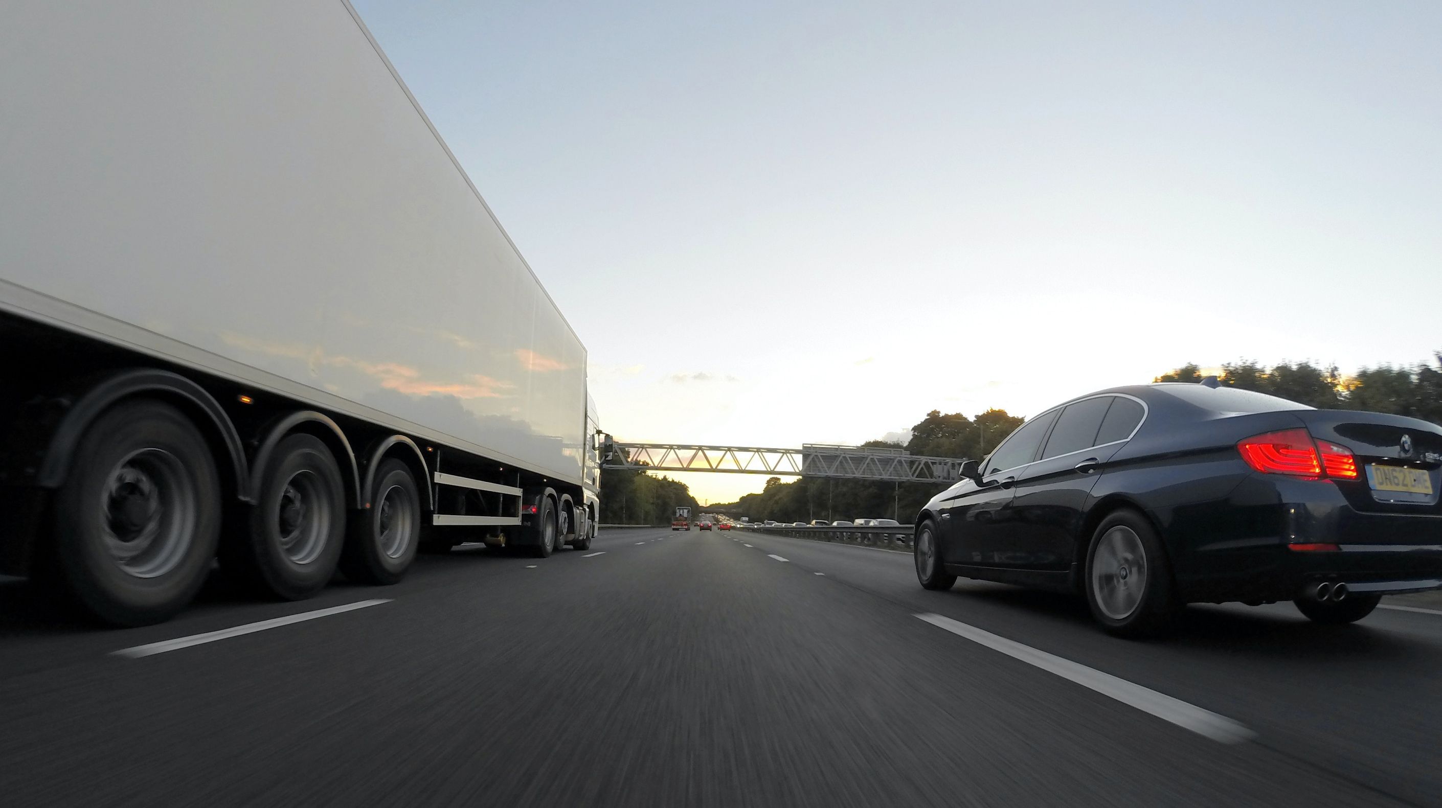 Snelweg met vrachtwagen en auto boven blog over boetes tachograaf