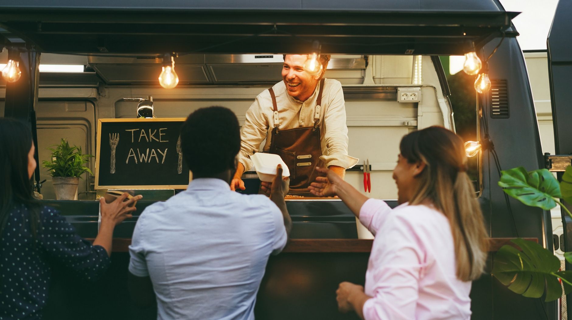 A few customers eating out at a food truck that is enabled by temporary internet solutions